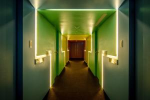 台北谷墨商旅的一条带绿色墙壁和长走廊的走廊