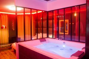 鲁昂L'Espace Privé 2 Rouen的一间带红色照明的大浴缸的浴室