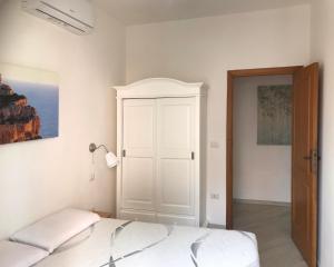阿尔盖罗Home Feeling Mascagni - Bilocale的卧室配有一张床和一个白色衣柜