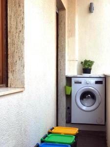 阿尔盖罗Home Feeling Mascagni - Bilocale的洗衣房配有洗衣机和窗户