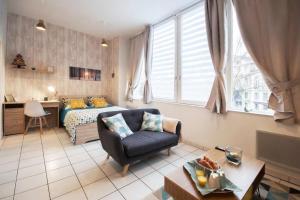 圣布里厄Appart'Confort - Le Scandi-Cosy的客厅配有床、沙发和椅子