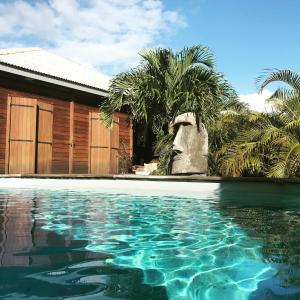 圣勒Villa Moai 974的棕榈树屋前的游泳池