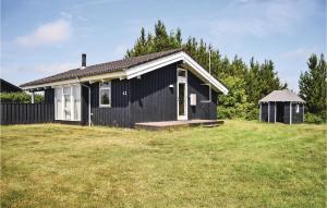 Krejbjerg3 Bedroom Gorgeous Home In Ejstrupholm的黑白房子,有草地庭院