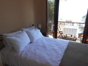 阿吉奥斯伊欧尼斯AUTUMN TO SUMMER的卧室内的一张带白色床单和枕头的床
