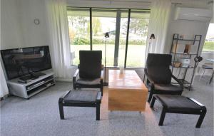 VemmenæsLiljebo的客厅配有桌子、两把椅子和电视
