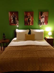 海牙艾玛住宿加早餐旅馆的一间卧室设有一张大床,拥有绿色的墙壁