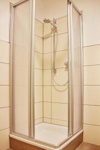 贝格海姆Joos Hotel的浴室里设有玻璃门淋浴