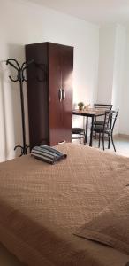 伊瓜苏港Pacurí Hotel的一间卧室配有一张床和一张桌子及椅子