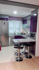 塞埃Shell's Beach apartament的厨房配有紫色橱柜和大理石台面
