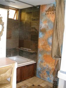 圣地亚哥秘密花园酒店的带浴缸的浴室和墙上的绘画