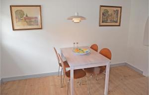 阿森斯Beautiful Home In Assens With Kitchen的餐桌,椅子和一碗水果