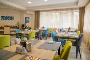图兹拉Hotel Soni Lux的餐厅设有木桌、椅子和窗户