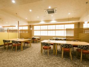 Jozankei哈娜末米吉日式旅馆的用餐室设有桌椅和窗户。