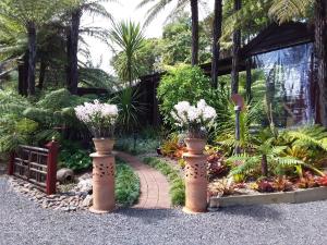 科罗曼德镇Bali Haven的花园内有两个花瓶,里面花朵