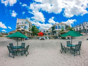 莫龙Brisa Marina Beach Resort powered by Cocotel的海滩上的一组椅子和遮阳伞