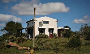何塞伊格纳西奥El Rancho de arenas de Jose Ignacio的坐在田野顶上的白色房子
