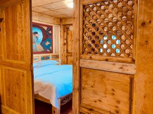 香格里拉香格里拉市香野听雨酒店的一间卧室设有一张床和木墙