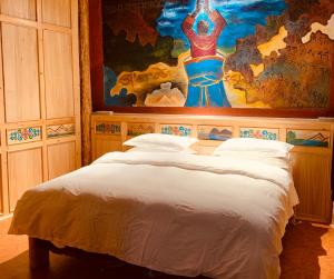 香格里拉香格里拉市香野听雨酒店的一间卧室配有一张壁画床