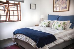 约翰内斯堡Springbank Guest Suite的一间卧室配有一张带蓝色毯子的床