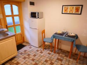 佩奇Tettyei Házikó的厨房配有小桌子和冰箱。