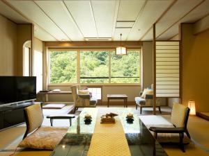 Jozankei哈娜末米吉日式旅馆的客厅设有桌子和大窗户