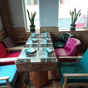 香格里拉香格里拉市香野听雨酒店的椅子房间里一张桌子和杯子