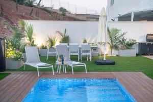 提比里亚Michaelangelo Luxury Garden Apartment with Private Pool的一个带桌椅的庭院和一个游泳池