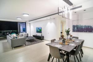 提比里亚Michaelangelo Luxury Garden Apartment with Private Pool的用餐室以及带桌椅的起居室。