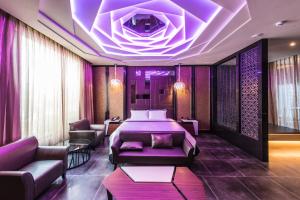 台中市悦河精品旅馆的酒店客房,配有一张床和紫色照明