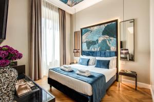 罗马Hotel 55 Fifty-Five - Maison d'Art Collection的酒店客房配有一张带蓝色枕头的大床
