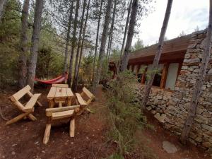 Gaytaninovo奥玛雅生态村酒店的小屋旁的树林里摆放着野餐桌椅