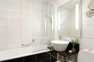 诺尔雪平诺尔雪平伊力特格兰德酒店的白色的浴室设有水槽和浴缸。