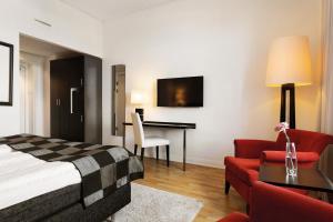 诺尔雪平诺尔雪平伊力特格兰德酒店的酒店客房配有一张床、一张桌子和一把椅子。