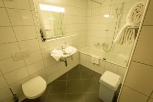 安特特泽Apart Holidays - Marina Walensee的浴室配有卫生间、盥洗盆和浴缸。