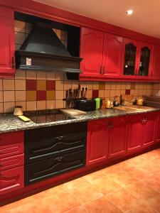 奥尔迪诺Casa Rustica Cabanes的红色的厨房配有红色橱柜和炉灶