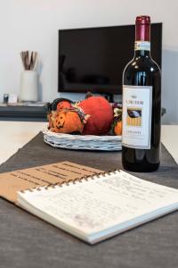 帕拉伊阿Tosca's House的坐在桌子旁的一瓶葡萄酒和一本书