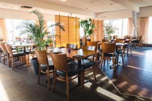 瑟沃格沃加尔酒店的餐厅设有木桌和椅子,种有植物