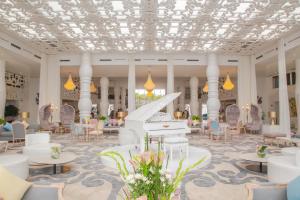 丹吉尔法拉丹吉尔酒店的配有白色钢琴和椅子的宏伟大堂