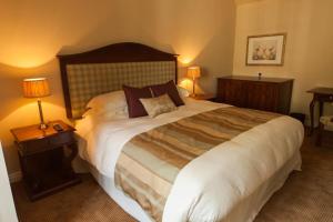 格兰瑟姆伍德豪斯阿姆斯宾馆的一张大床,位于酒店带两盏灯的房间