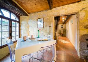 贝纳克和卡泽纳克Au coeur de Beynac, gite authentique et confortable的厨房配有石墙内的桌椅