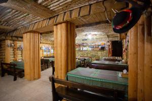 亚列姆切Nebokrai的餐厅设有木柱子、桌子和帽子