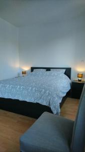MasevauxLe Gite du Relais的一间卧室配有一张带白色床罩和椅子的床