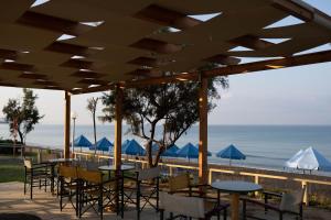 库鲁塔Harmony Hotel的一个带桌椅的庭院和海滩