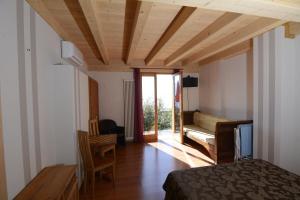 提尼亚类Il Camino的一间卧室配有一张床、一张桌子和一张沙发