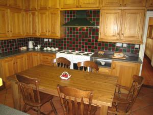亨利因阿登Ashleigh House - HOT TUB, Snooker table, Sleeps 24的厨房配有木桌和炉灶。