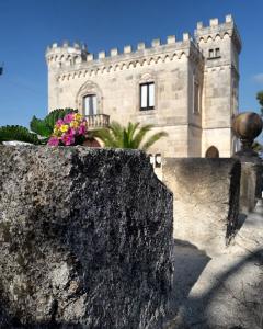 奥斯图尼Rocca Giulia的一座石头墙的建筑,上面有鲜花