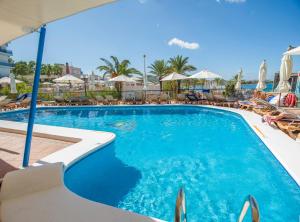 圣安东尼奥奥西里斯伊比萨酒店的一个带椅子和遮阳伞的游泳池