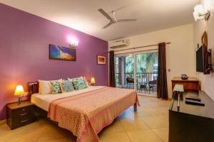 巴加Heritage Exotica Villa - 4BHK, Baga的一间卧室配有一张紫色墙壁的床