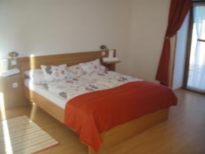 保克什Paks Panzió的一间卧室配有一张带红色毯子的床