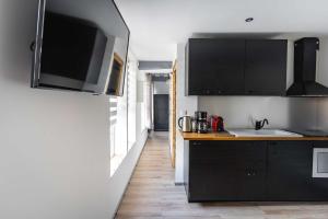 卢维耶La Dimiere - Le Postel - Appartements de standing en hyper-centre - Louviers的厨房配有黑色橱柜和水槽